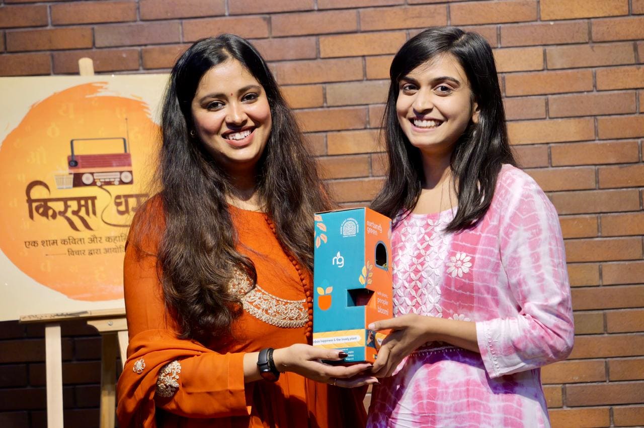 A Quissa Ghar organiser presenting a prize to a performer on stage