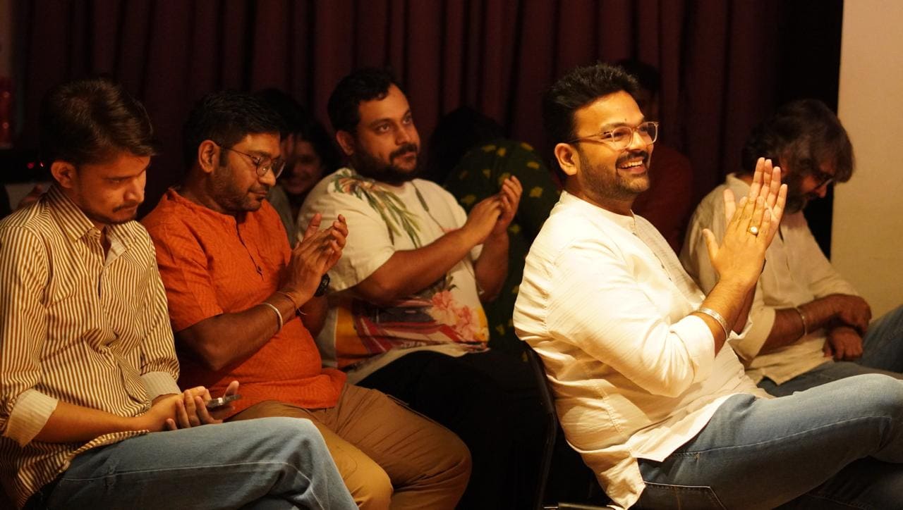 Audience members smiling and listening during a Quissa Ghar session