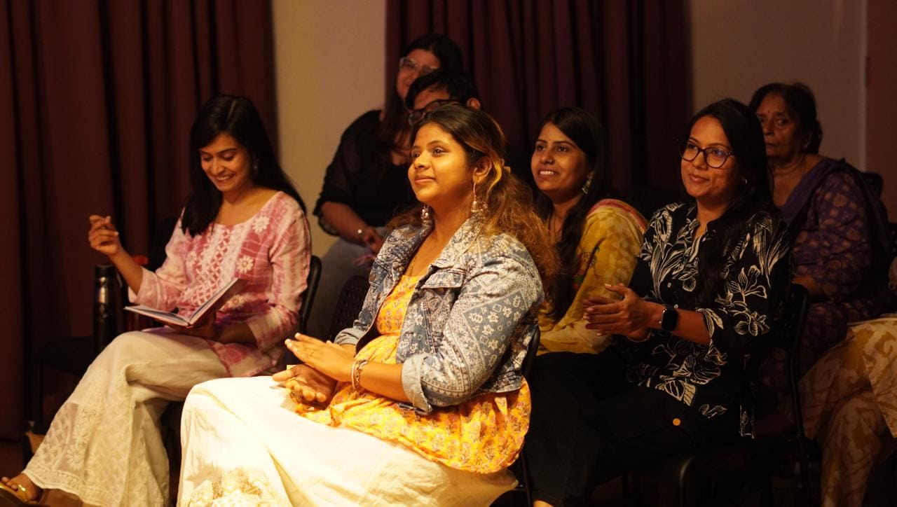 An audience member smiling warmly during a Quissa Ghar session