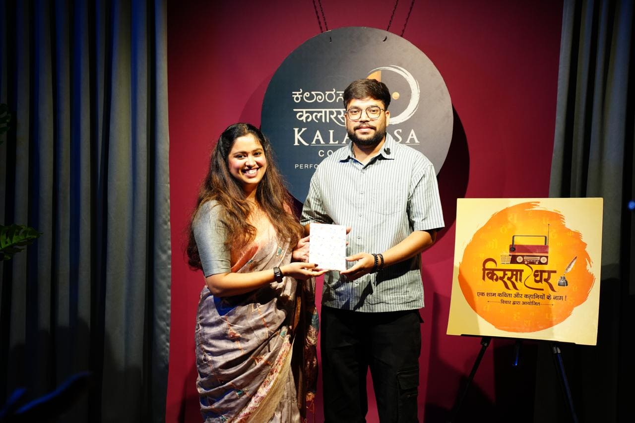 Two performers smiling together on stage after a recognition moment
